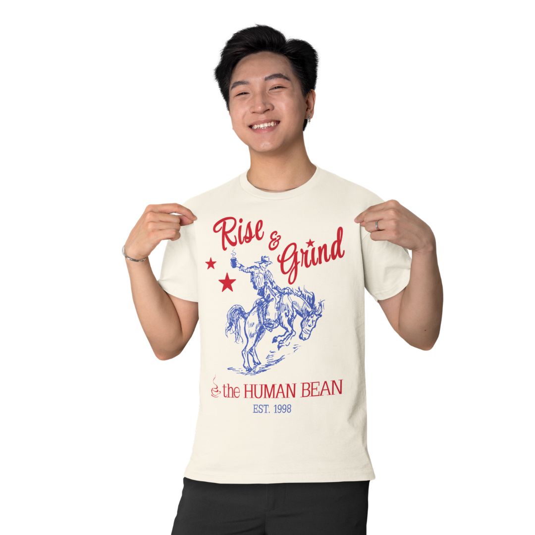 Rise and Grind beige tee with red and blue cowboy design