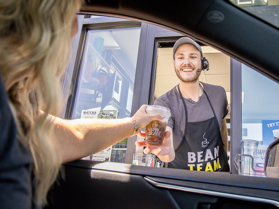 A woman receiving her drink at The Human Bean drive-through